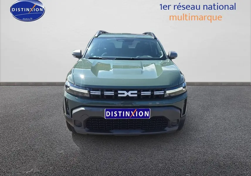Vue frontale du Dacia Duster 2025 vert kaki avec calandre moderne et phares LED fins allumés.