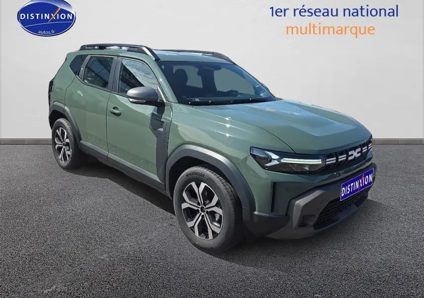 Vue 3/4 avant d'un Dacia Duster vert kaki 2025 avec jantes alu et barres de toit noires.