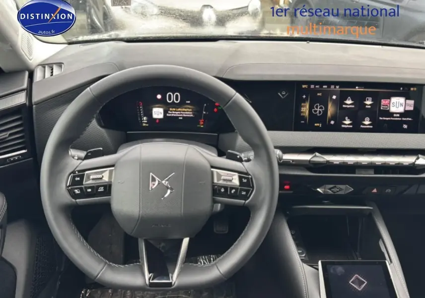 Vue intérieure centrée sur le volant cuir et le tableau de bord numérique du DS4 gris platinium 2024 hybride.