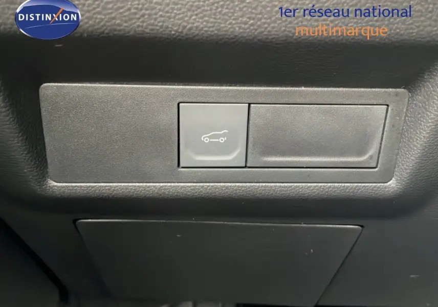 Bouton d'ouverture du coffre sur tableau de bord noir intérieur Renault Symbioz 2025.