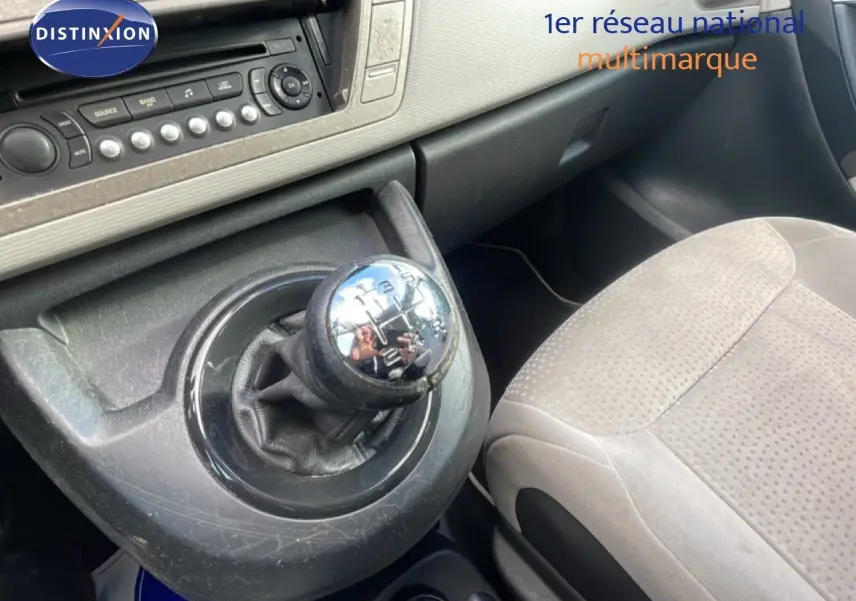 Gros plan sur le levier de vitesses manuel et la console centrale du Citroën C4 Picasso noir métal, intérieur tissu beige.