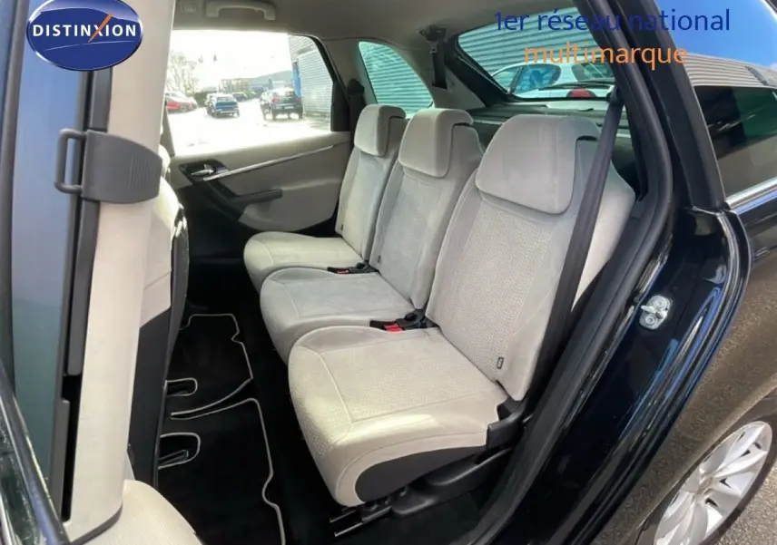 Vue intérieure côté droit montrant les sièges arrière beige clair d'une Citroën C4 Picasso noir métal de 2008.