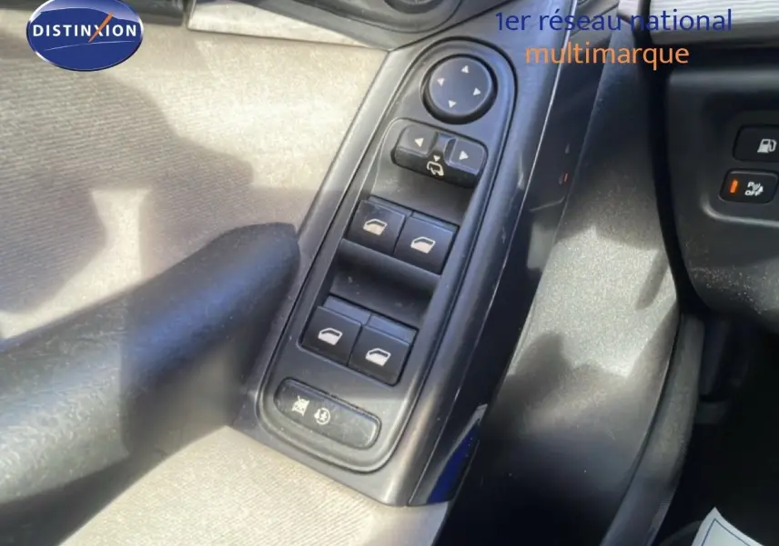 Vue rapprochée des commandes des vitres électriques et rétroviseurs côté conducteur d'une Citroën C4 Picasso noir métal de 2008.