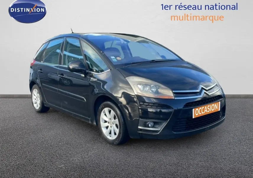 Citroën C4 Picasso noir métal en 3/4 avant droit, avec jantes alliage et calandre distinctive.