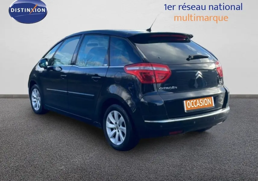 Vue 3/4 arrière droite d'une Citroën C4 Picasso noire métal de 2008 avec jantes alliage et toit vitré.