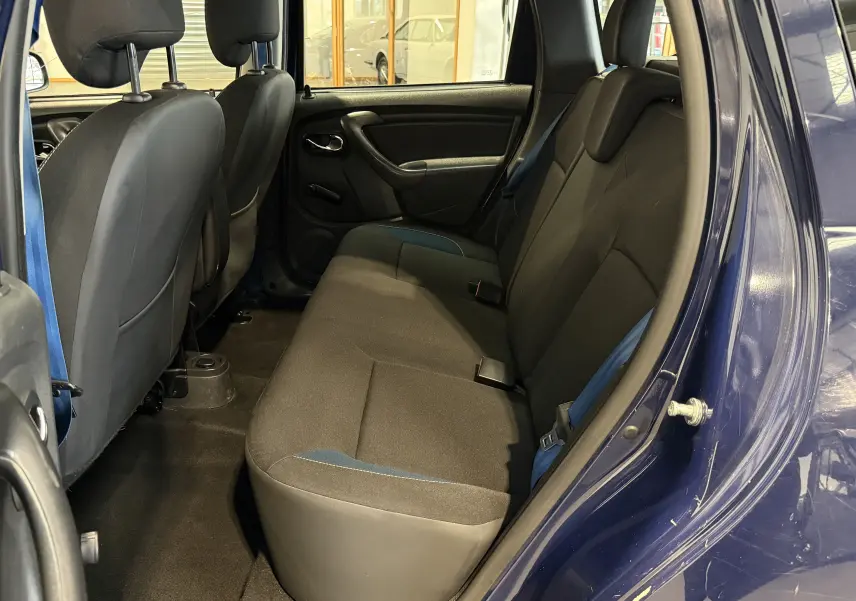 Vue intérieure côté droit sur la banquette arrière noire avec détails bleus du Dacia Duster bleu 2015.