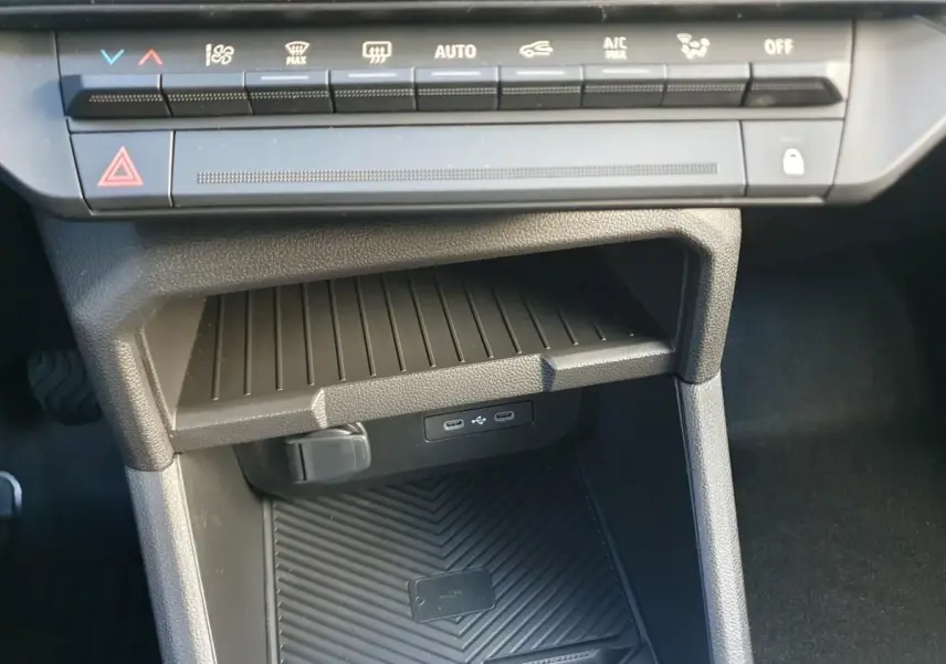 Vue rapprochée de la console centrale du Dacia Duster 2026, montrant les commandes climatisation et deux prises USB type C.
