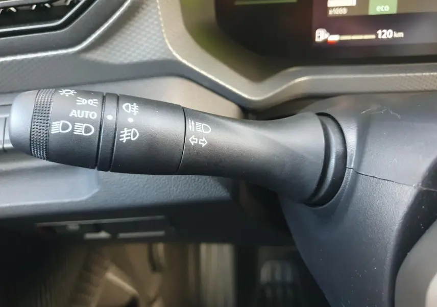 Gros plan sur la commande des feux et clignotants du Dacia Duster 2026, intérieur noir mat.