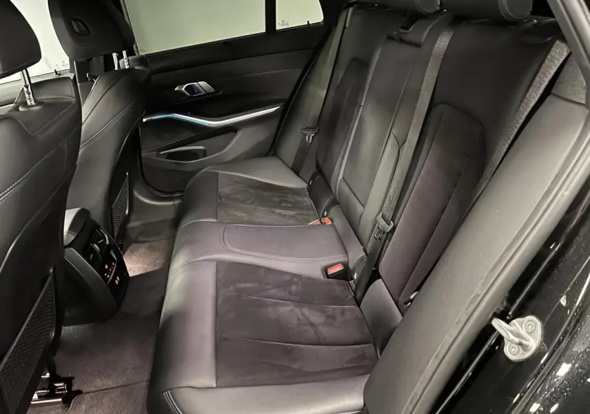 Vue intérieure côté droit sur la banquette arrière en cuir noir avec détails Alcantara de la BMW Série 3 Touring 320e M Sport.