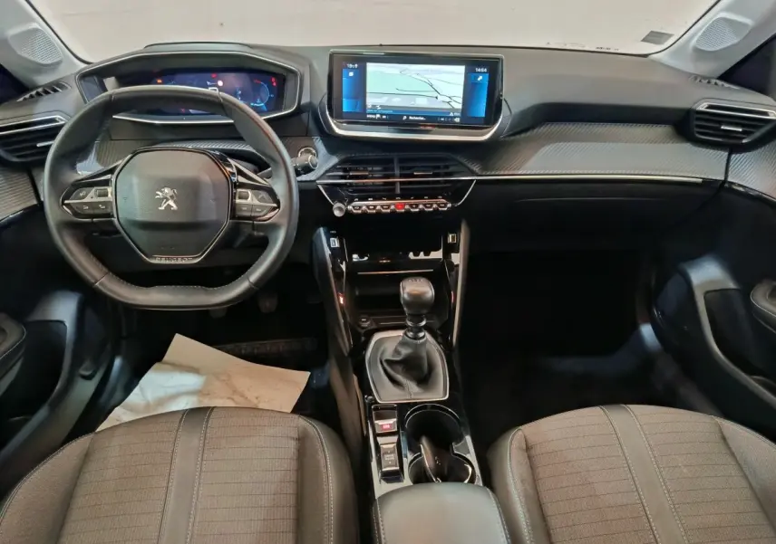 Intérieur de la Peugeot 208 blanc, vue de face sur le tableau de bord avec écran tactile 10 pouces et volant cuir.