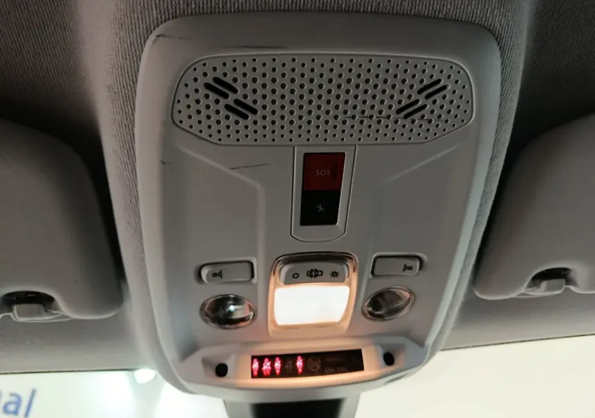 Vue en gros plan du plafonnier intérieur blanc avec commandes d'éclairage et bouton SOS du Peugeot 208 blanc.