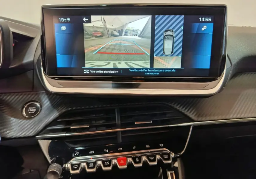 Vue rapprochée de l’écran tactile central affichant la caméra de recul dans l’habitacle noir d’une Peugeot 208 blanche.