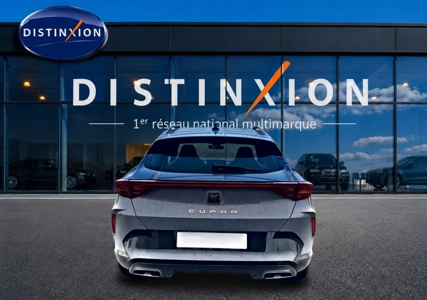 Vue arrière du CUPRA Formentor gris graphene 2026 avec feux LED et double sortie d'échappement, devant un showroom Distinxion.