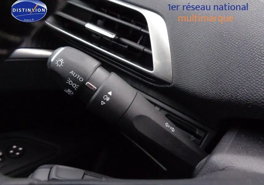 Gros plan sur la commande des feux et clignotants dans l'habitacle noir du Peugeot 3008 Gris Artense 2023.