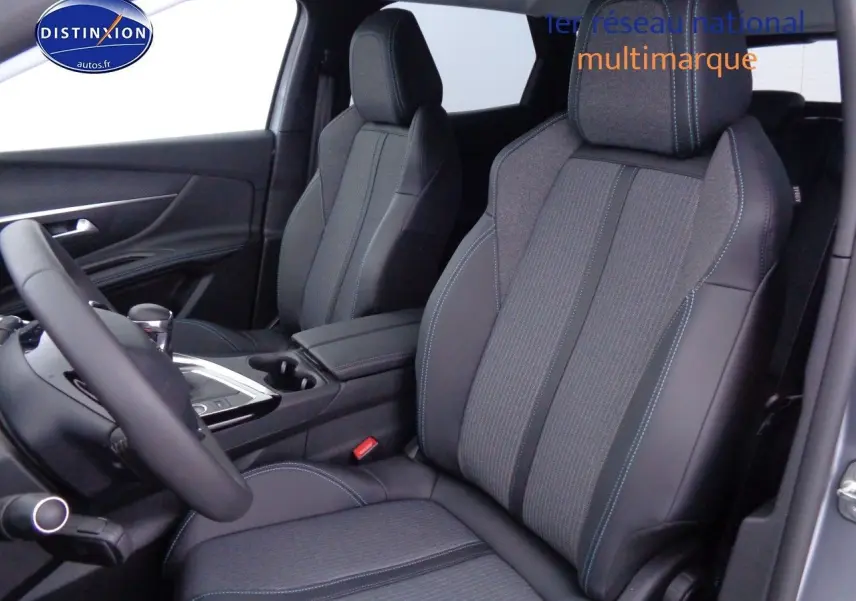 Vue intérieure côté conducteur du Peugeot 3008 2023 avec sièges mixtes tissu et cuir noir aux surpiqûres bleues.