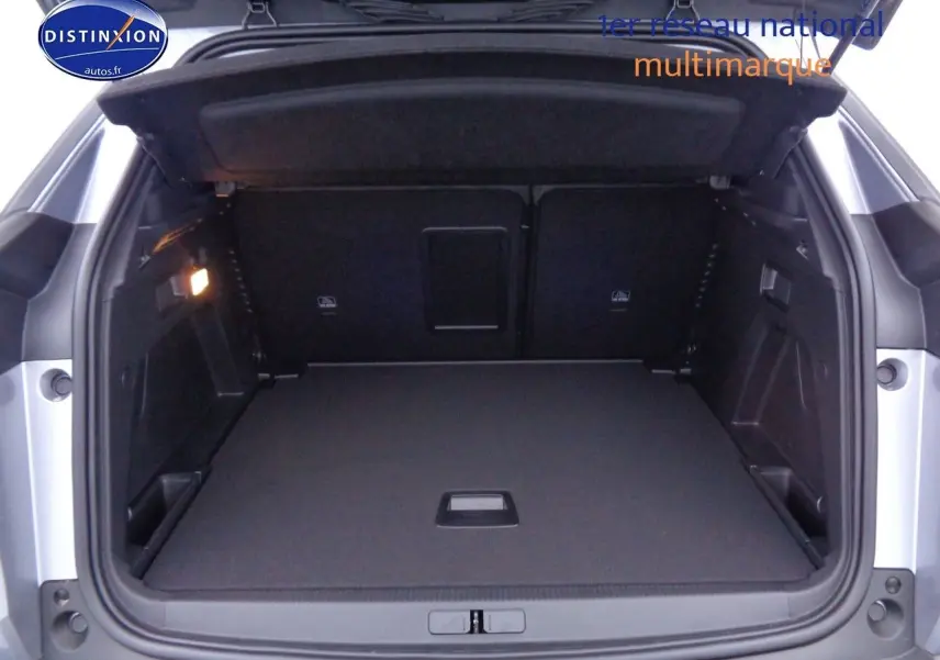 Coffre ouvert vu de l'arrière d'un Peugeot 3008 gris Artense métal, montrant un espace de chargement propre et spacieux.