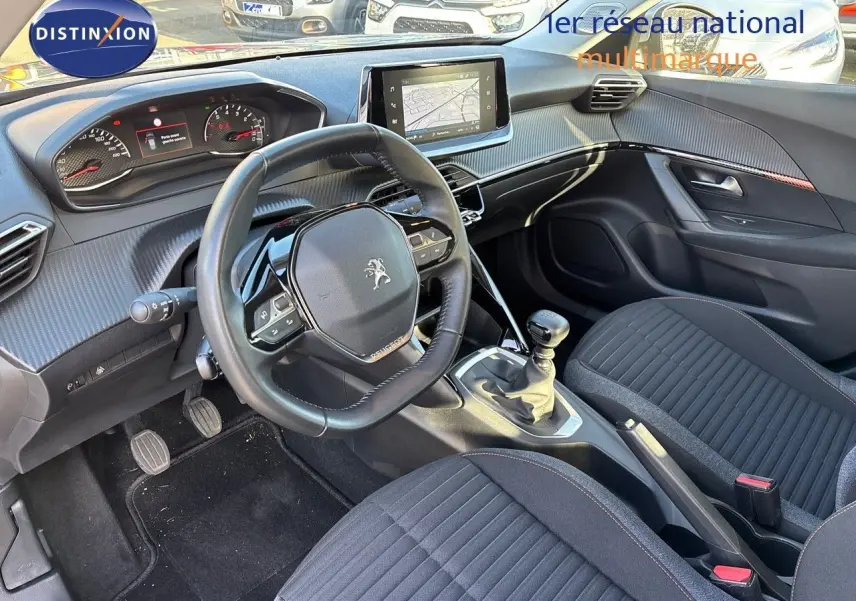 Intérieur avant du Peugeot 2008 gris Artense 2021, vue sur le volant, tableau de bord et levier de vitesse manuel.