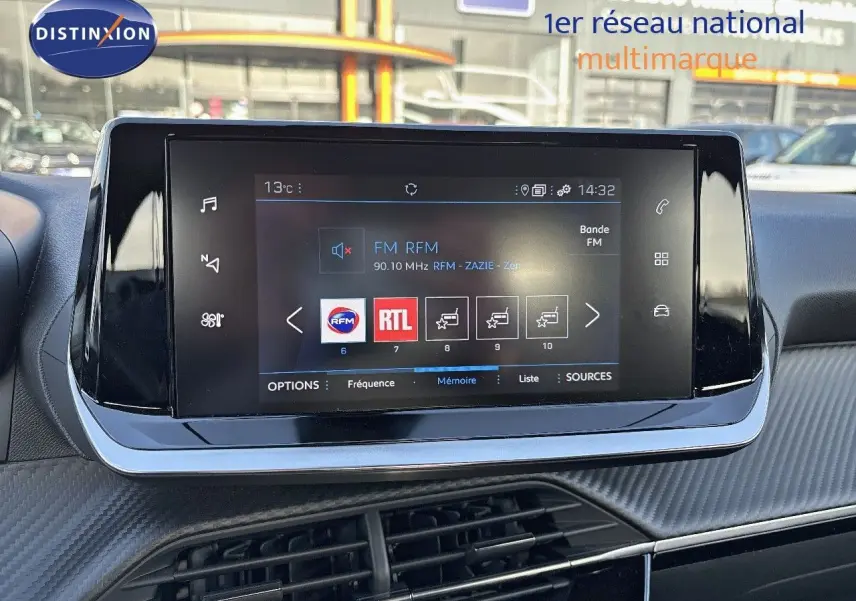 Écran tactile central du tableau de bord du Peugeot 2008 gris Artense, affichant la radio FM RFM à 14h32.