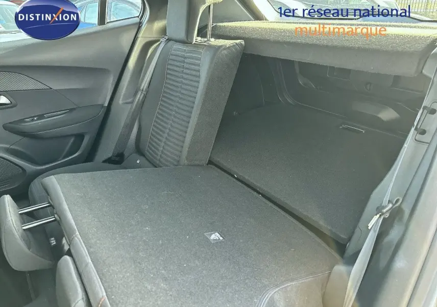Vue intérieure du coffre et des sièges arrière rabattus côté droit d'un Peugeot 2008 gris Artense 2021.