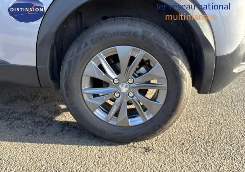 Gros plan sur la roue avant droite d'un Peugeot 2008 gris Artense avec jante alliage 16 pouces.