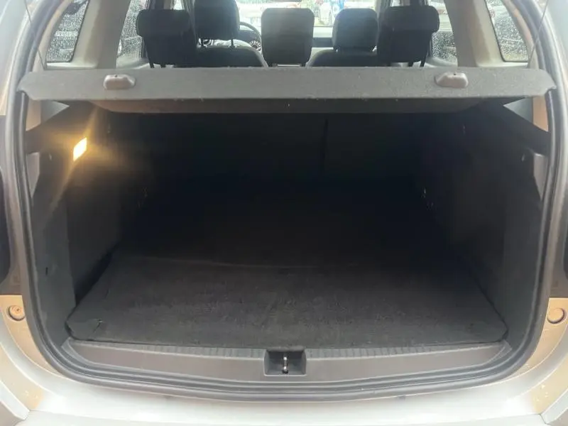 Coffre ouvert vu de l'arrière du Dacia Duster gris Comète 2021, montrant l'espace de chargement et la tablette cache-bagages.