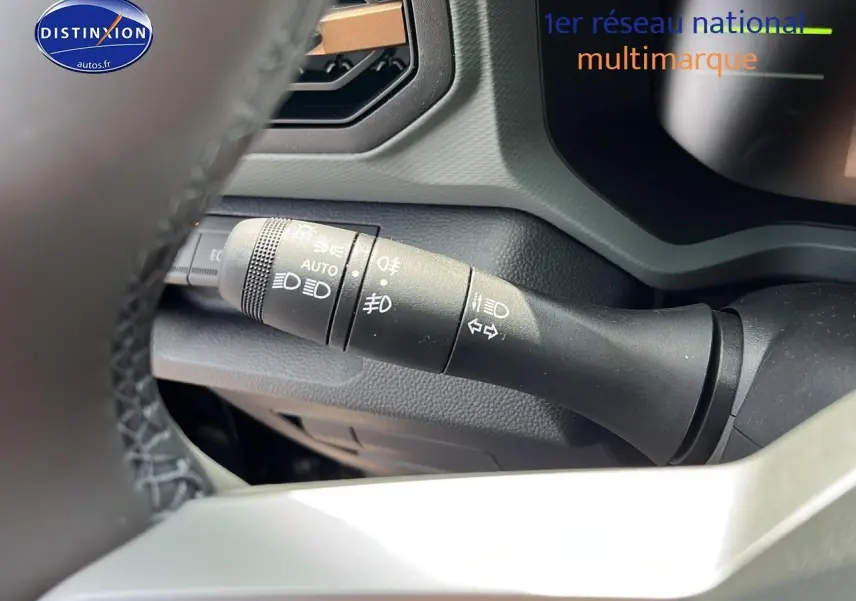 Gros plan sur la commande des phares et clignotants du tableau de bord du Dacia Duster 2025 noir.