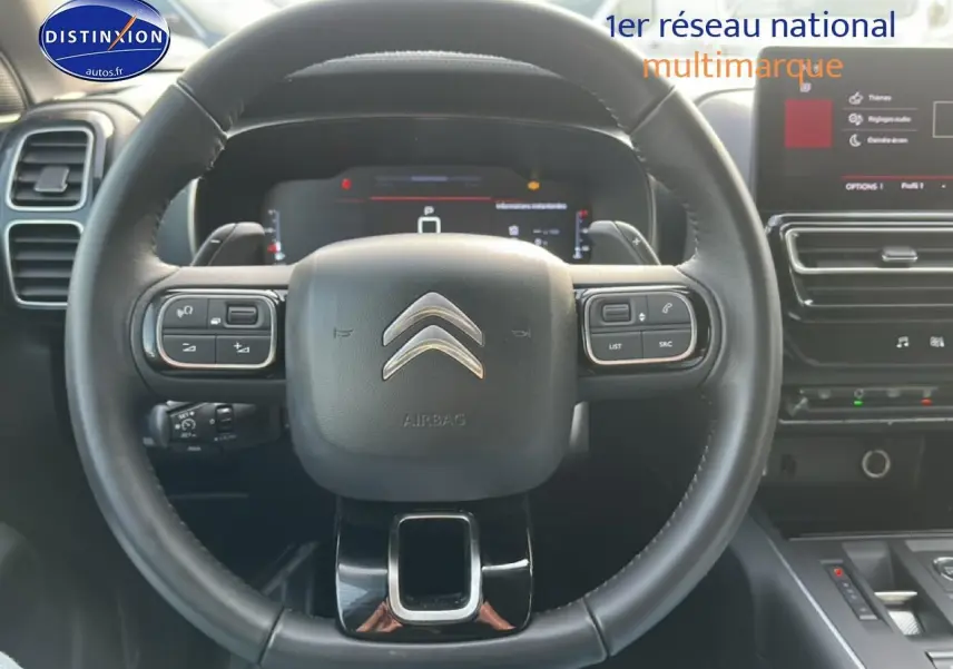 Vue rapprochée du volant cuir multifonction noir du Citroën C5 Aircross 2025 avec tableau de bord numérique et écran tactile.