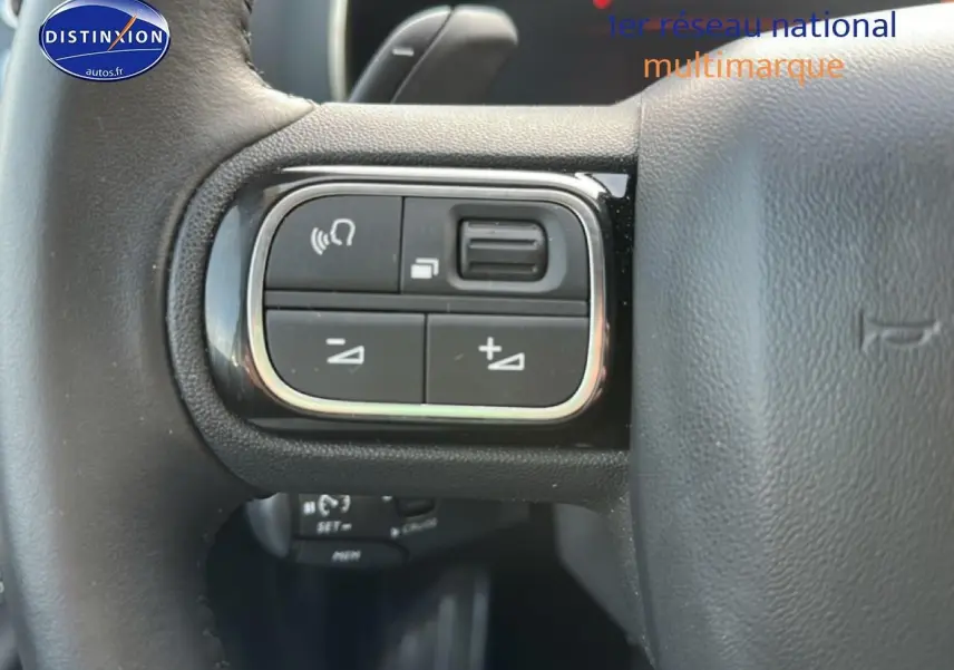 Gros plan sur les commandes multifonctions à gauche du volant cuir noir du Citroën C5 Aircross 2025.