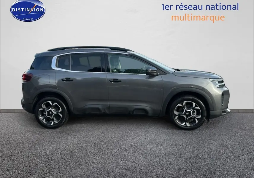 Profil droit du Citroën C5 Aircross noir 2025 avec jantes alu et barres de toit visibles.
