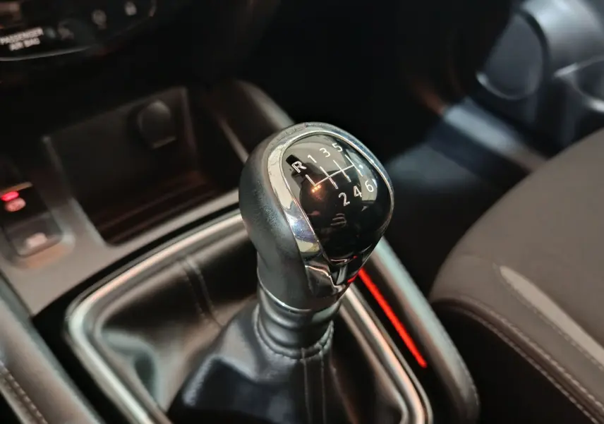 Gros plan sur le levier de vitesses manuel noir et chrome du Nissan Qashqai 1.5 DCI 2019, intérieur sombre.