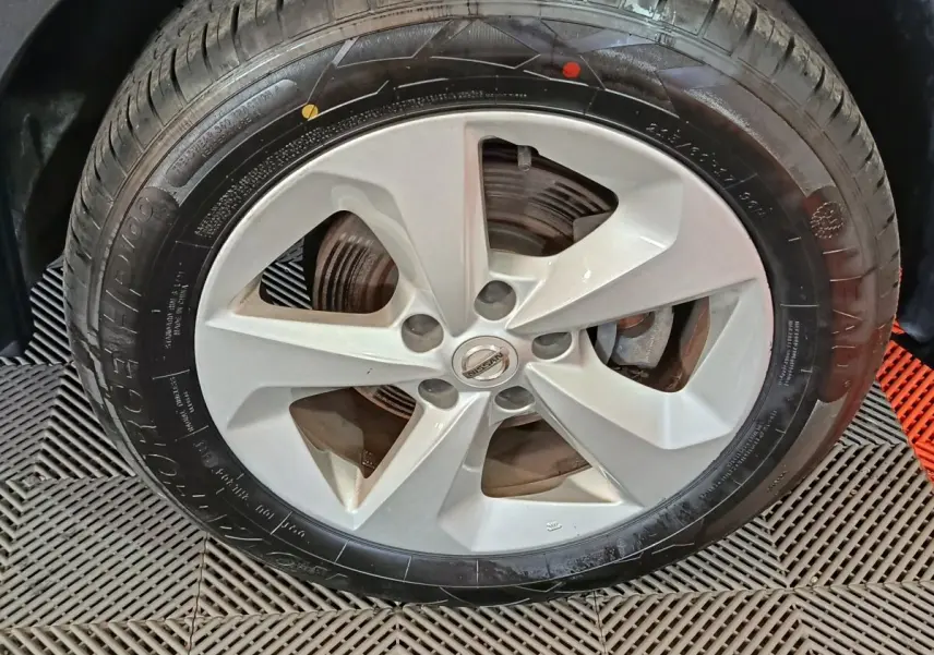 Gros plan sur la roue avant droite avec jante argentée du Nissan Qashqai gris clair 2019.