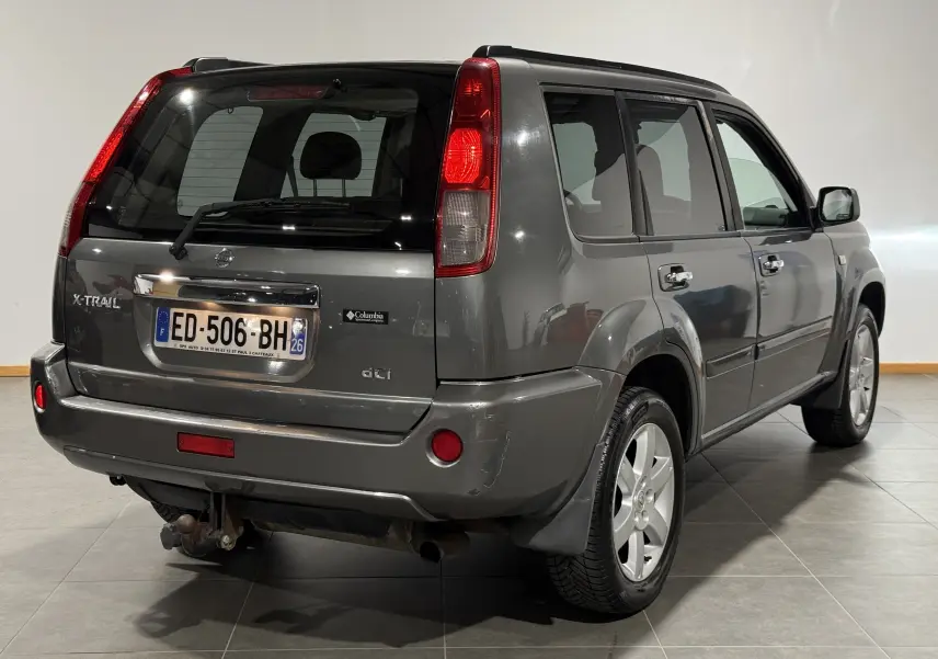 Vue 3/4 arrière droite du Nissan X-TRAIL Columbia gris 2006 avec attelage et logo Columbia visible sur le hayon.