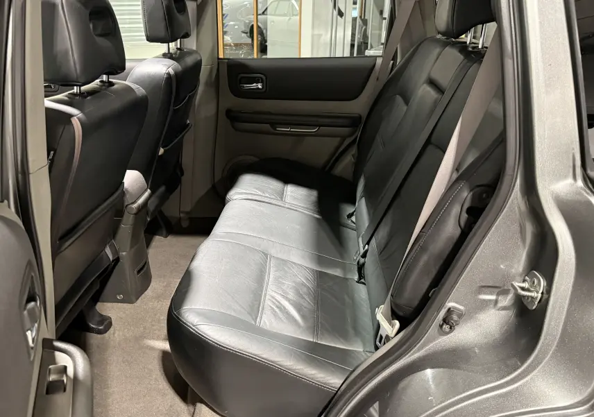 Vue intérieure côté droit des sièges arrière en cuir noir du Nissan X-TRAIL Columbia gris, avec ceinture de sécurité visible.