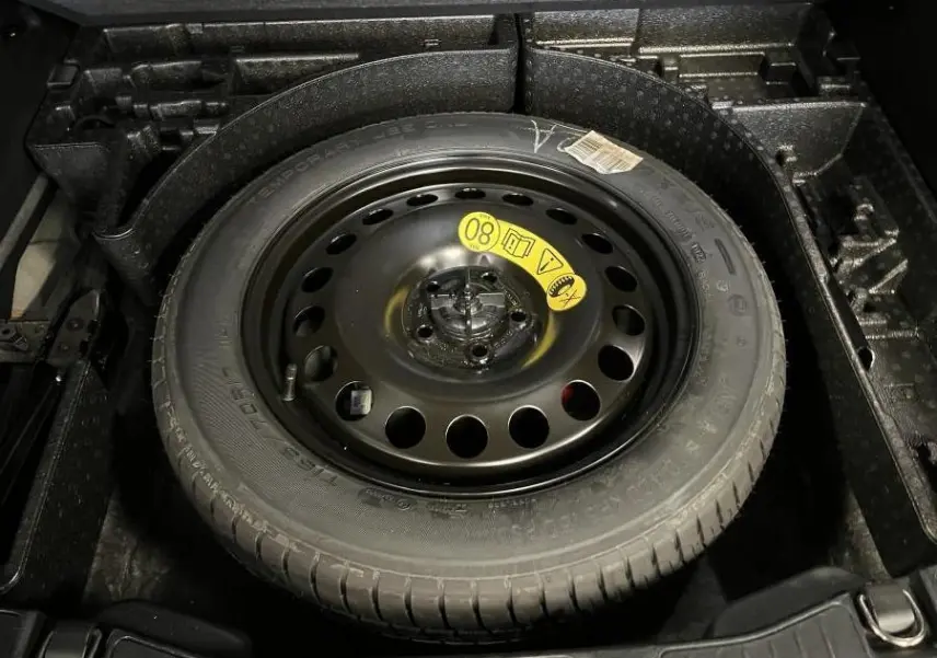 Roue de secours galette noire 17 pouces dans le coffre d’un Ford Kuga 2022 version ST-Line noir.