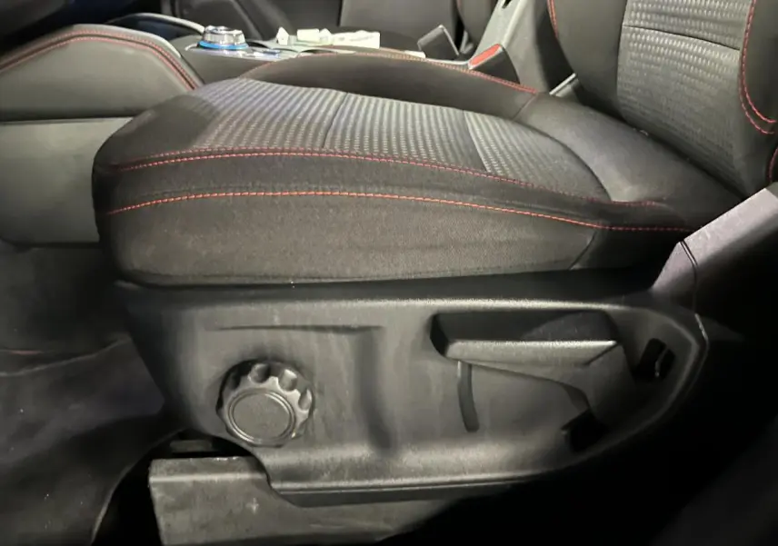 Gros plan sur le siège avant conducteur noir avec surpiqûres rouges du Ford Kuga 2022 version ST-Line.