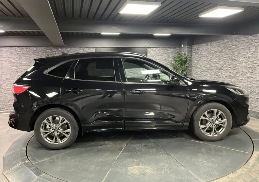 Ford Kuga noir vue de profil côté gauche, avec jantes alliage 18 pouces et vitres arrière surteintées.