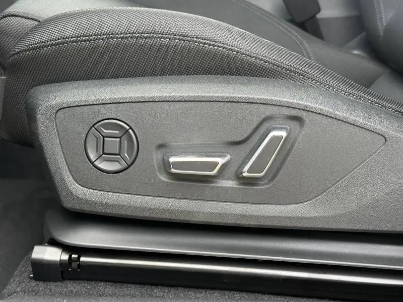 Gros plan sur les commandes de réglage électrique du siège conducteur de l'Audi Q3 2.0 TDI 150ch S line 2026 noir Mythique.