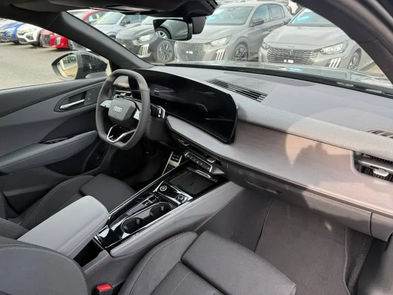 Vue intérieure côté conducteur de l'Audi Q3 2026, tableau de bord moderne avec écran large et finitions noires élégantes.