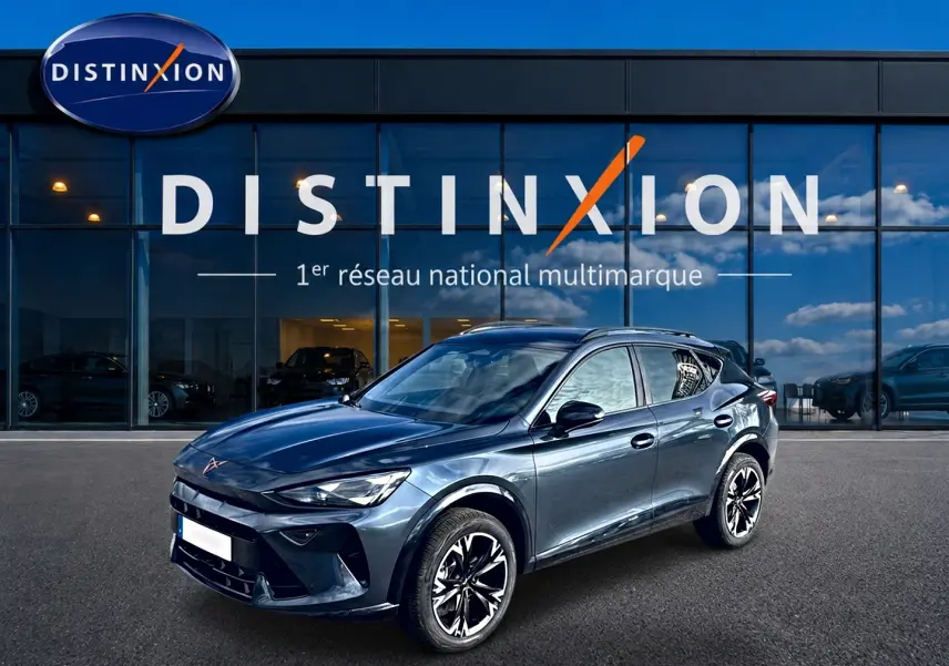 Vue 3/4 avant droit d’un CUPRA Formentor gris magnétique avec jantes noires et toit ouvrant, devant une vitrine Distinxion.