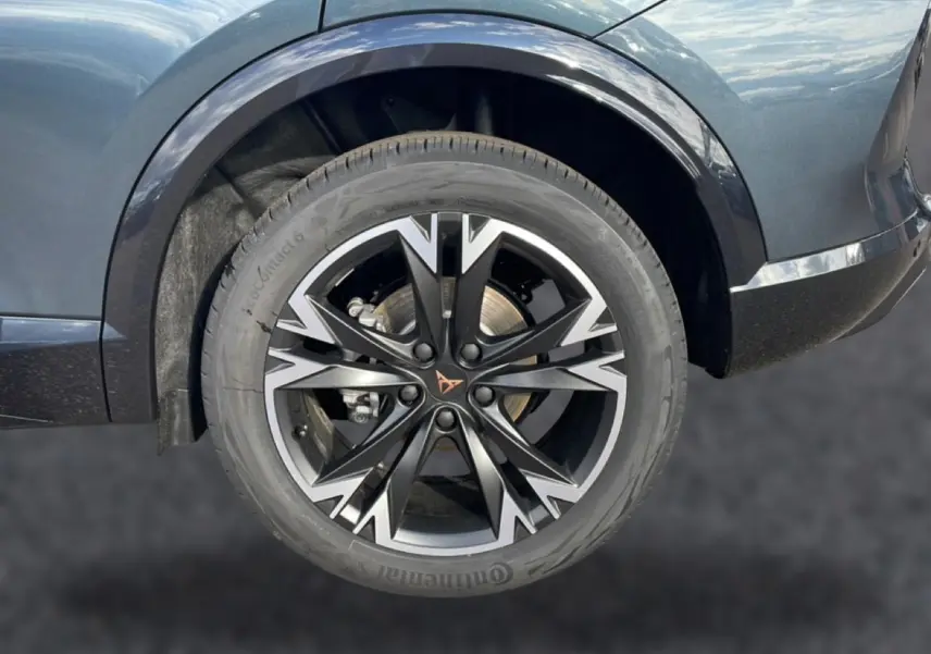 Gros plan sur la roue avant gauche du CUPRA Formentor gris magnétique avec jante noire et argentée au design sportif.