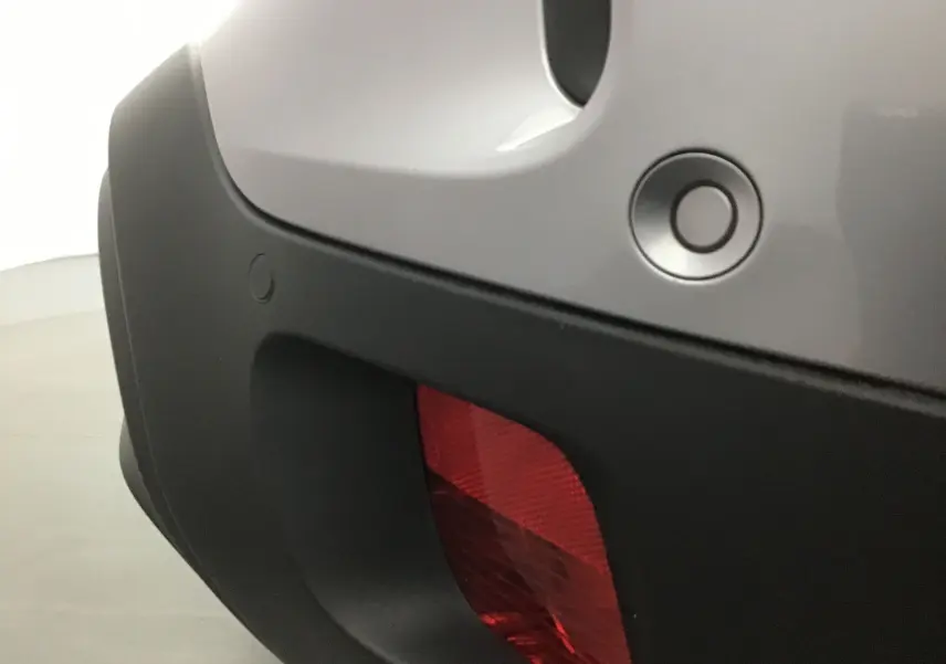 Gros plan sur le feu arrière rouge et le pare-chocs gris Artense d'une Citroën C5 Aircross 2021.