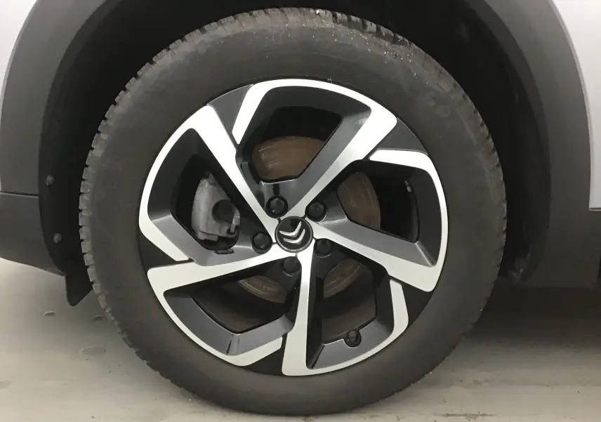 Gros plan sur la jante alliage bicolore du côté gauche d'un Citroën C5 Aircross gris Artense de 2021.