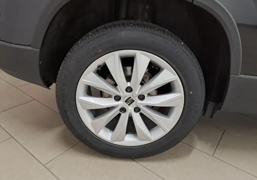 Gros plan sur la roue avant droite d’un SEAT Ateca noir Minuit, mettant en valeur la jante alliage argentée à 10 branches.