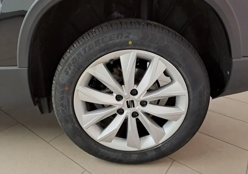 Gros plan sur la roue avant droite du SEAT Ateca noir Minuit, jante alliage argent à dix branches.