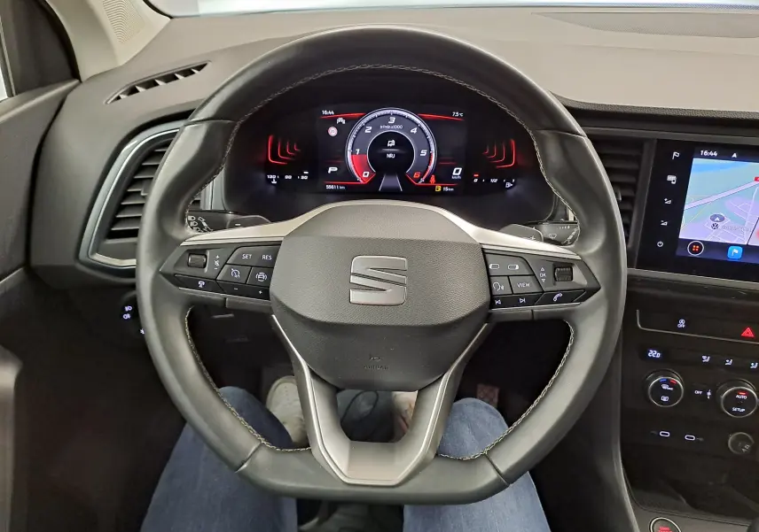 Vue intérieure centrée sur le volant noir du SEAT Ateca 2023 avec tableau de bord numérique et écran tactile latéral.
