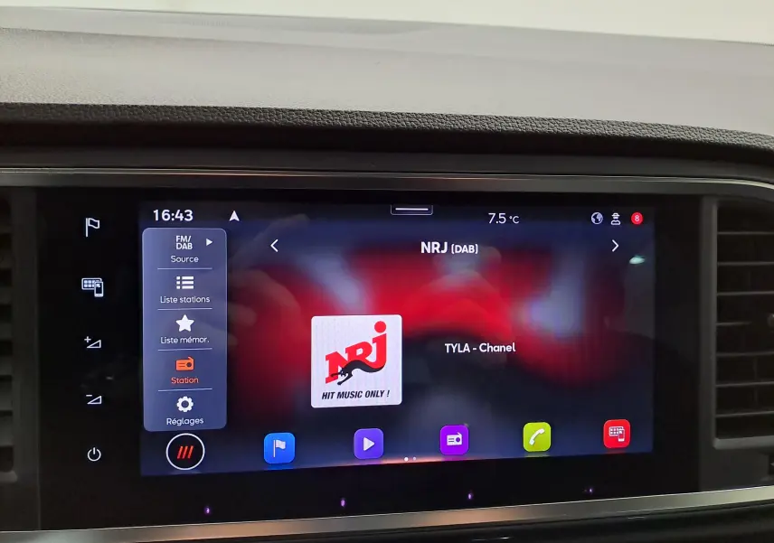 Écran tactile central du tableau de bord du SEAT Ateca 2023 affichant la radio NRJ en DAB, ambiance intérieure noire.