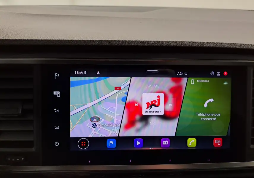 Vue avant rapprochée du tableau de bord noir Titane du SEAT Ateca 2023, écran tactile affichant navigation et radio NRJ.