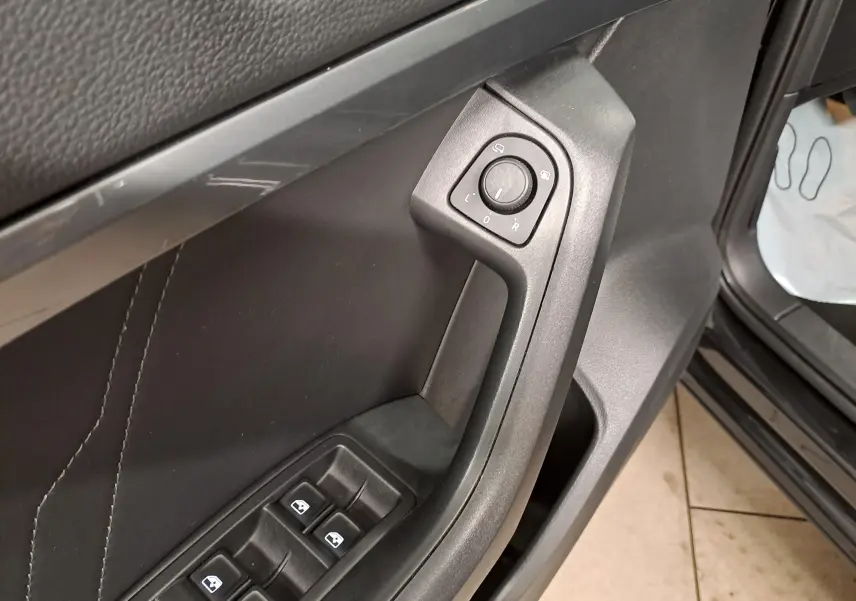 Détail de la commande des rétroviseurs et des vitres sur la porte avant gauche du SEAT Ateca noir Minuit 2023.