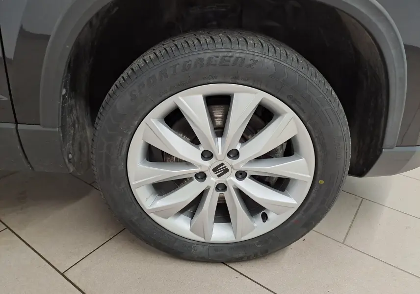Gros plan sur la roue avant droite d’un SEAT Ateca Noir Minuit, mettant en valeur la jante argentée à 10 branches.
