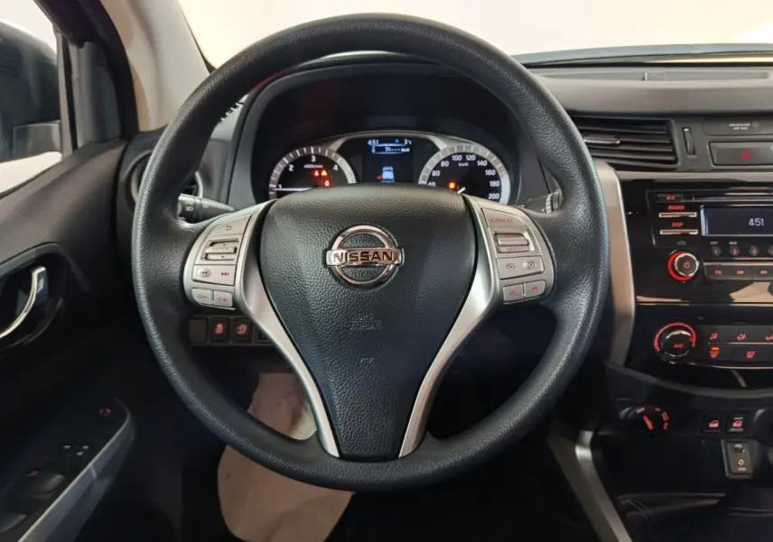 Vue centrée sur le volant multifonctions noir du Nissan Navara 2018 avec tableau de bord et console centrale visibles.
